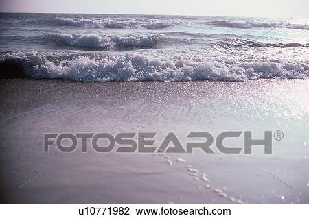 Stock Image - Breakers On Sandy Shore. Fotosearch