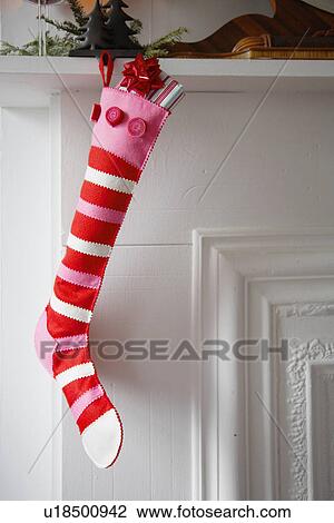 Christmas stocking with presents hanging from shelf View Large Photo Image Stock Image - Christmas stocking with presents hanging from shelf. Fotosearch