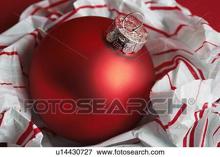 Red bauble on wrapping paper View Large Photo Image Stock Photo - Red bauble on wrapping paper. Fotosearch
