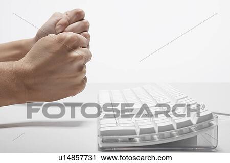 Stock Image - Woman's fists near computer keyboard (close-up). Fotosearch