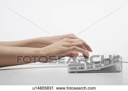 Stock Image - Young woman typing with computer (close-up). Fotosearch
