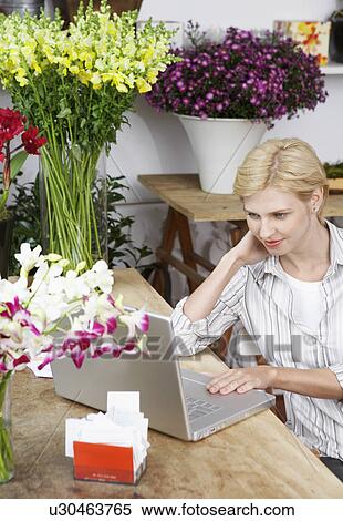 Stock Photography - Female florist using laptop. Fotosearch