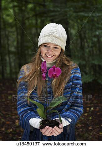 Mid Adult Woman Holding Orchid in Forest View Large Photo Image Stock Photo - Mid Adult Woman Holding Orchid in Forest. Fotosearch