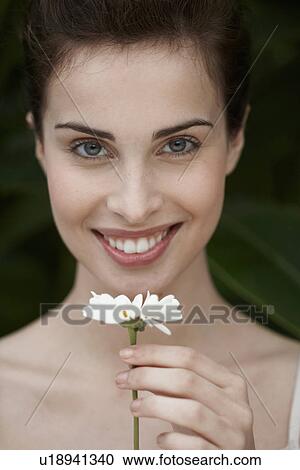 Young woman holding daisy View Large Photo Image Stock Image - Young woman holding daisy. Fotosearch