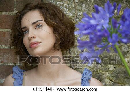 Young woman near flowers View Large Photo Image Stock Photo - Young woman near flowers. Fotosearch