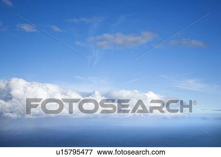 Stock Photo - Blue sky with white puffy clouds. Fotosearch