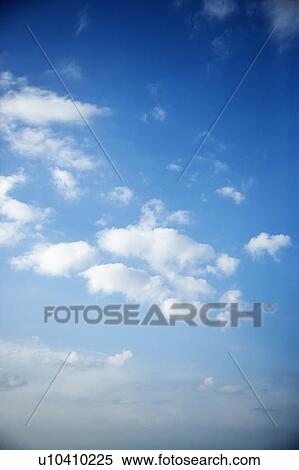 Stock Photography - Fluffy cumulus clouds in blue sky.. Fotosearch