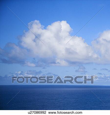 Stock Image - Pacific ocean and blue sky with puffy clouds.. Fotosearch