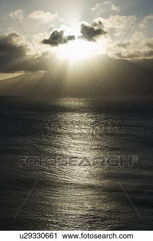 Pacific ocean and island with sun streaming through clouds View Large Photo Image Stock Image - Pacific ocean and island with sun streaming through clouds. Fotosearch