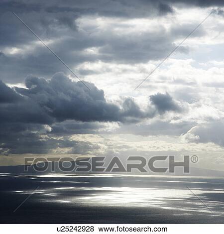 Stock Photo - View of island in Pacific ocean with clouds from Maui, Hawaii.. Fotosearch