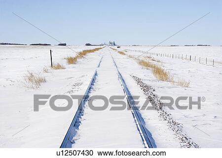 Railroad tracks in snow covered rural landscape View Large Photo Image Stock Image - Railroad tracks in snow covered rural landscape. Fotosearch