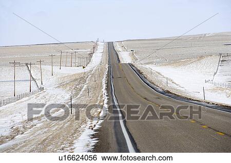 Road over rolling hill landscape with snow and power lines View Large Photo Image Stock Photograph - Road over rolling hill landscape with snow and power lines. Fotosearch