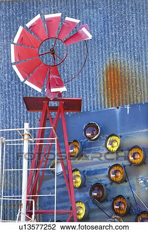 Broken red windmill against rusted blue corrugated metal building covered in taillights View Large Photo Image Stock Image - Broken red windmill against rusted blue corrugated metal building covered in taillights. Fotosearch