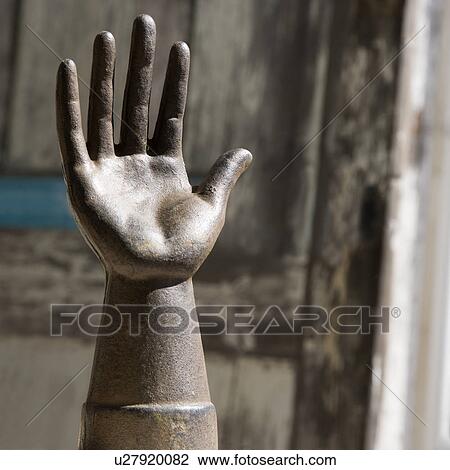 Metal statue of hand against wooden background. View Large Photo Image Stock Image - Metal statue of hand against wooden background.. Fotosearch