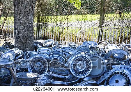 Stacks of old hubcaps on the ground next to tree. View Large Photo Image Stock Image - Stacks of old hubcaps on the ground next to tree.. Fotosearch