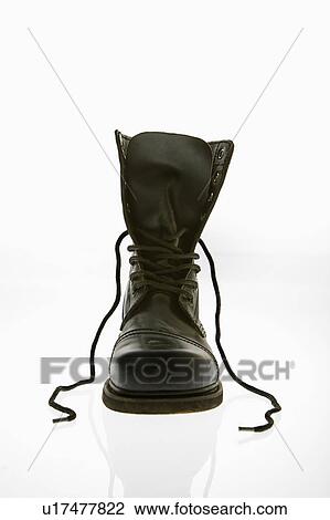 Stock Image - One black leather high top boots with untied laces.. Fotosearch