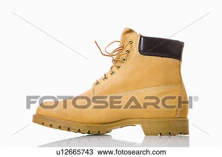 Stock Image - One tan work boot. . Fotosearch