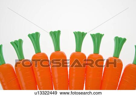 Stock Photo - Bunch of plastic carrots lined up on white background.. Fotosearch
