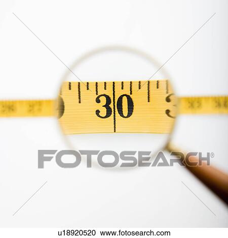 Magnifying glass held over measuring tape View Large Photo Image Stock Image - Magnifying glass held over measuring tape. Fotosearch