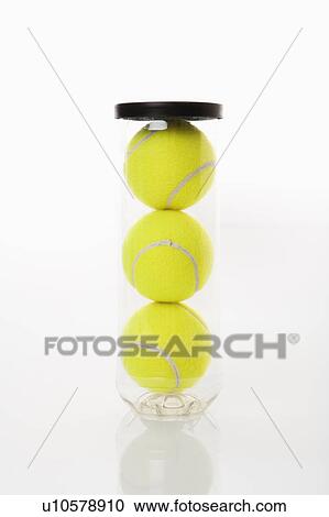 Stock Image - New tennis balls stacked in plastic container. Fotosearch