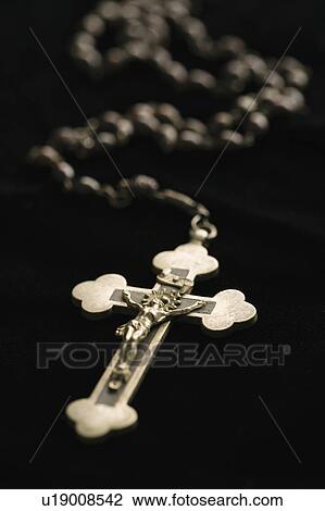 Stock Image - Christian rosary beads with crucifix on black background.. Fotosearch