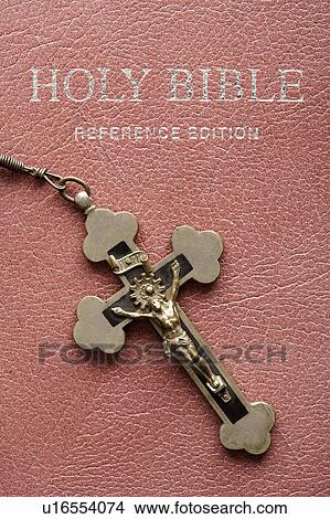 Picture - Crucifix lying on cover of closed Holy Bible. Fotosearch