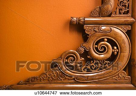 Stock Photo - Ornate wooden furniture carving against orange wall. Fotosearch