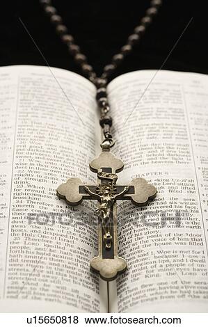 Rosary with crucifix lying on open Bible View Large Photo Image Stock Photo - Rosary with crucifix lying on open Bible. Fotosearch