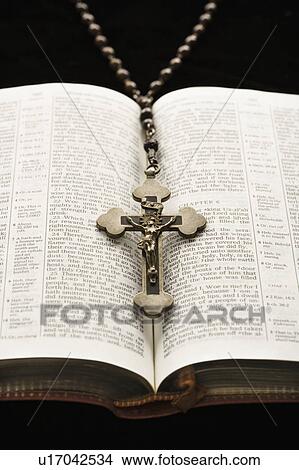 Picture - Rosary with crucifix lying on open Bible.. Fotosearch