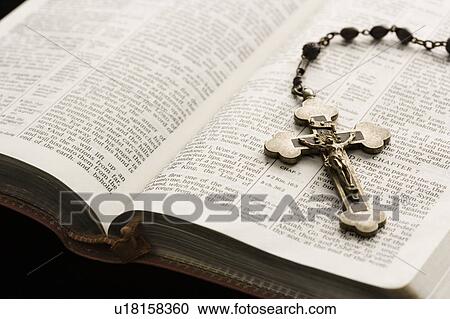 Rosary with crucifix lying on open Bible. View Large Photo Image Stock Image - Rosary with crucifix lying on open Bible.. Fotosearch