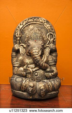 Statue of Hindu elephant Ganesha against orange wall View Large Photo Image Stock Image - Statue of Hindu elephant Ganesha against orange wall. Fotosearch