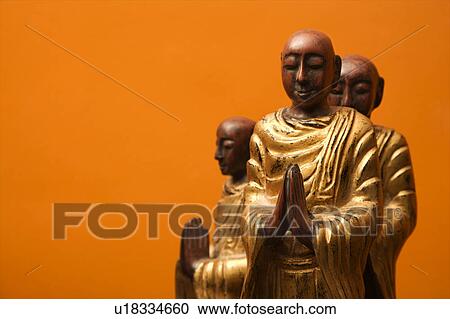Three wooden statues of Buddhist disciples against orange wall. View Large Photo Image Stock Image - Three wooden statues of Buddhist disciples against orange wall.. Fotosearch