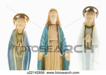 Stock Photograph - Virgin Mary statue with hands held out with angelic figures on each side against white background.. Fotosearch