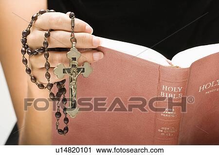 Woman holding Holy Bible open with rosary and crucifix in hand View Large Photo Image Stock Image - Woman holding Holy Bible open with rosary and crucifix in hand. Fotosearch