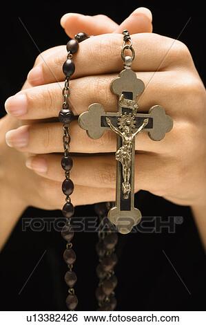 Stock Photograph - Woman holding rosary with crucifix. Fotosearch