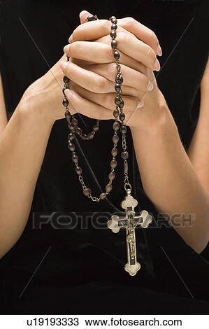 Woman holding rosary with hands clasped together View Large Photo Image Stock Image - Woman holding rosary with hands clasped together. Fotosearch
