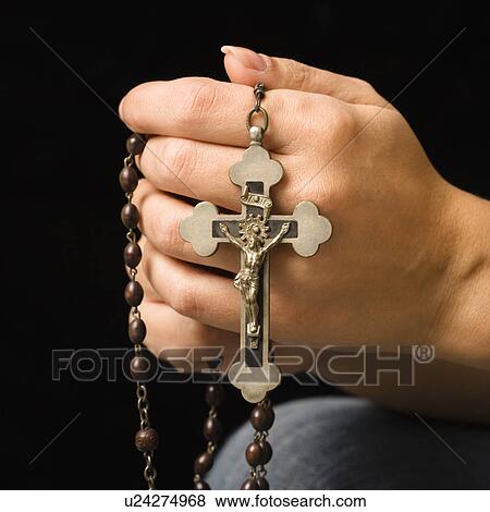 Stock Photo - Woman's hands holding rosary with crucifix.. Fotosearch