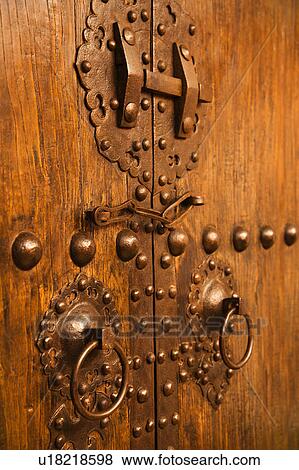 Stock Photo - Wooden doors with ornate metal knobs and locks. Fotosearch