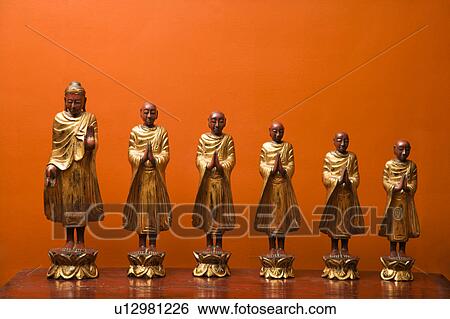 Wooden statues of Buddha with five disciples against orange wall. View Large Photo Image Stock Photograph - Wooden statues of Buddha with five disciples against orange wall.. Fotosearch