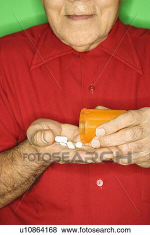 Emptying pill bottle into hand View Large Photo Image Stock Photo - Emptying pill bottle into hand. Fotosearch