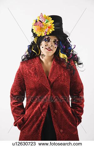 Stock Image - Woman in unique makeup and clothing standing against white background. Fotosearch