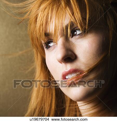 Close-up portrait of serious-looking young female looking off to the side. View Large Photo Image Picture - Close-up portrait of serious-looking young female looking off to the side.. Fotosearch