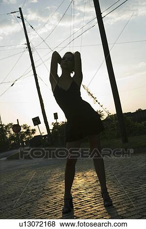 Silhouette adult blonde woman wearing little black dress posing in street. View Large Photo Image Stock Photo - Silhouette adult blonde woman wearing little black dress posing in street.. Fotosearch