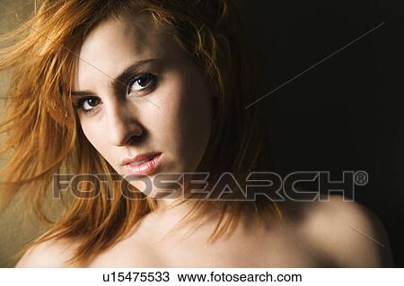 Stock Image - Studio portrait of pretty young redheaded female.. Fotosearch