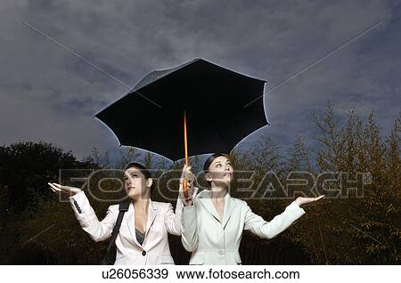 2 women under an umbrella View Large Photo Image Stock Photo - 2 women under an umbrella. Fotosearch