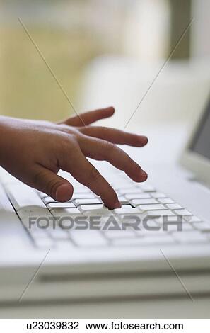 Stock Image - Close of child's hand on laptop. Fotosearch