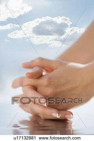Stock Image - Close-up of hands against a sky.. Fotosearch