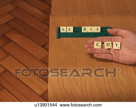 Hand holding letters from board game View Large Photo Image Picture - Hand holding letters from board game. Fotosearch