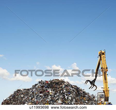Stock Photo - Mechanical grabber and scrap heap. Fotosearch