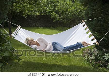 Smiling woman relaxing in hammock View Large Photo Image Stock Image - Smiling woman relaxing in hammock . Fotosearch